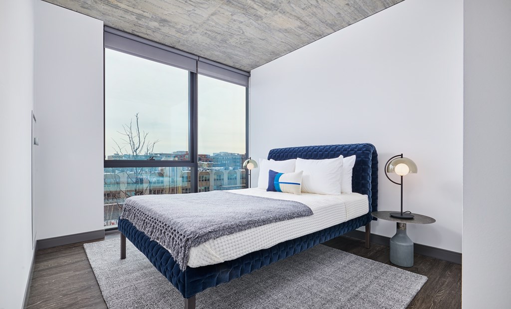 A bedroom with a large bed and a view of the city.