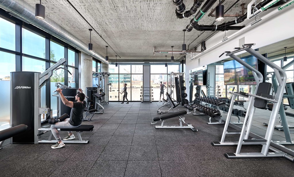 A man is working out in a gym with a variety of equipment.