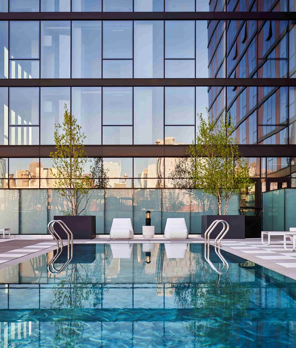 A modern pool area with a glass wall in the background.
