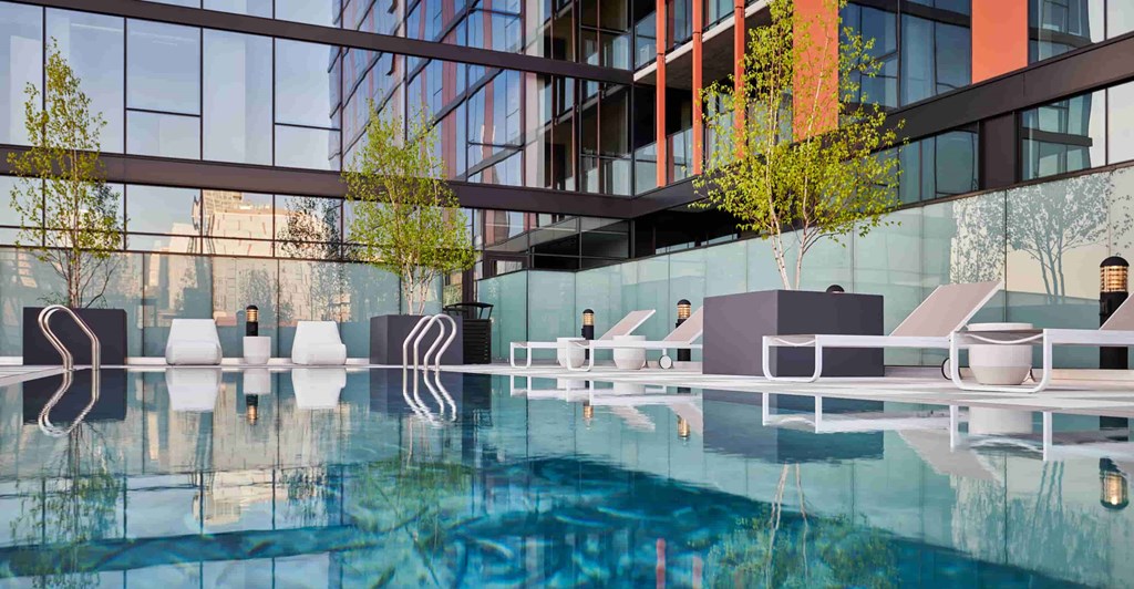A modern building with a pool in front.