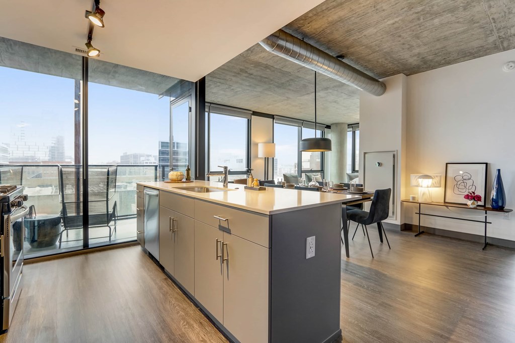 A modern kitchen with a large island and a view of the city.