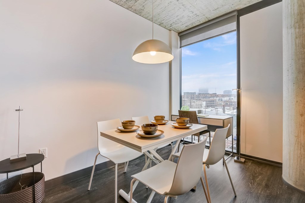 A modern dining room with a table set for four.
