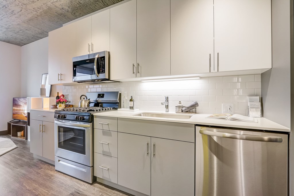 A modern kitchen with white cabinets and stainless steel appliances.