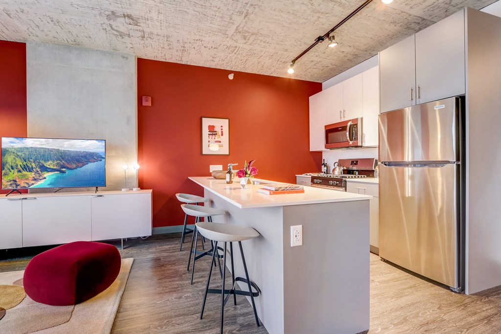 A modern kitchen with a white island and stainless steel appliances.