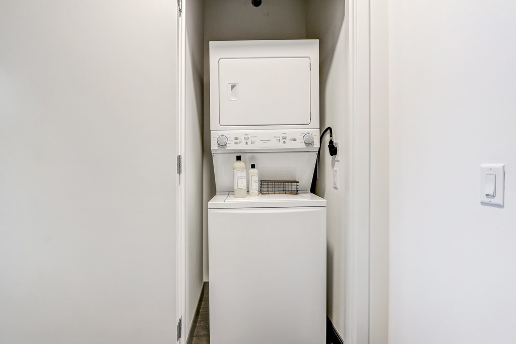 A white washing machine in a small white room.