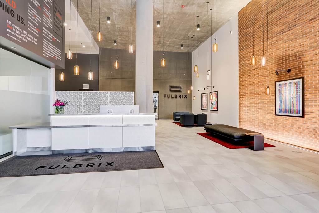 A Fulbrix reception area with a white reception desk and a brick wall.