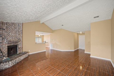 A living room with a fireplace and wood flooring.