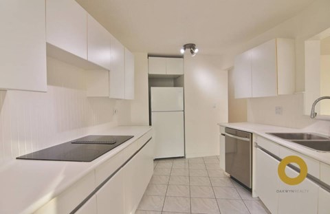 A kitchen with white cabinets and a sink.