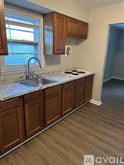 A kitchen with wooden cabinets and a marble countertop.