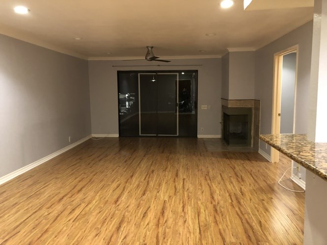 A room with wooden flooring and a ceiling fan.