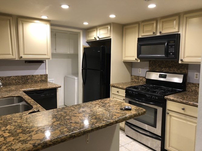 A kitchen with granite countertops and stainless steel appliances.