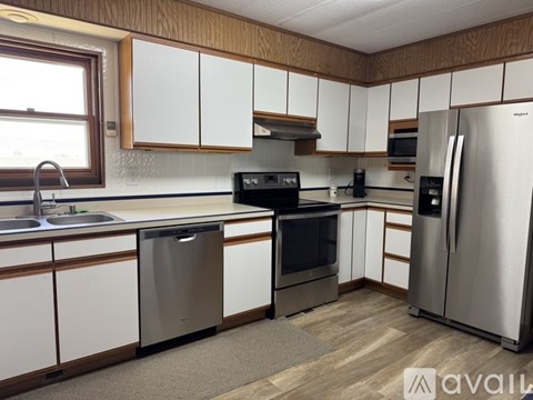 A kitchen with white cabinets and a stainless steel refrigerator.