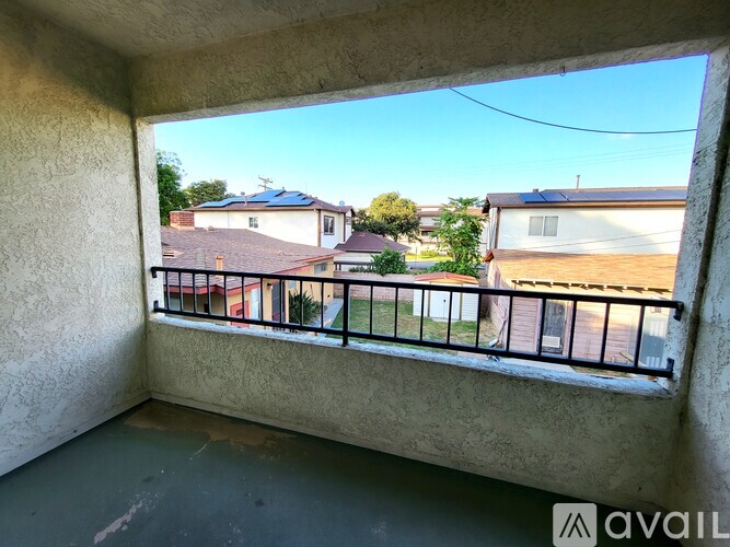 A balcony with a view of houses and trees.
