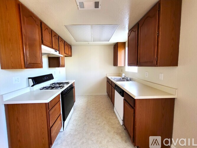 A kitchen with wooden cabinets and white countertops.
