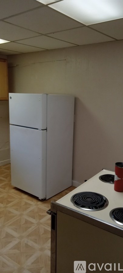 A white refrigerator and a stove top oven in a kitchen.
