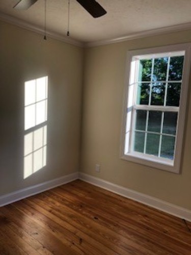 A room with a window and wooden floors.