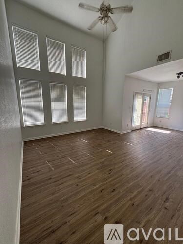 A room with wooden flooring and a ceiling fan.