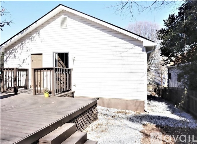 A white house with a deck and a fence.