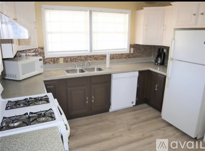 A kitchen with a white refrigerator, a white stove, and a white microwave.