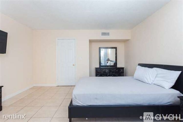 A bedroom with a bed, dresser, and mirror.