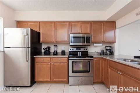 A kitchen with wooden cabinets and stainless steel appliances.