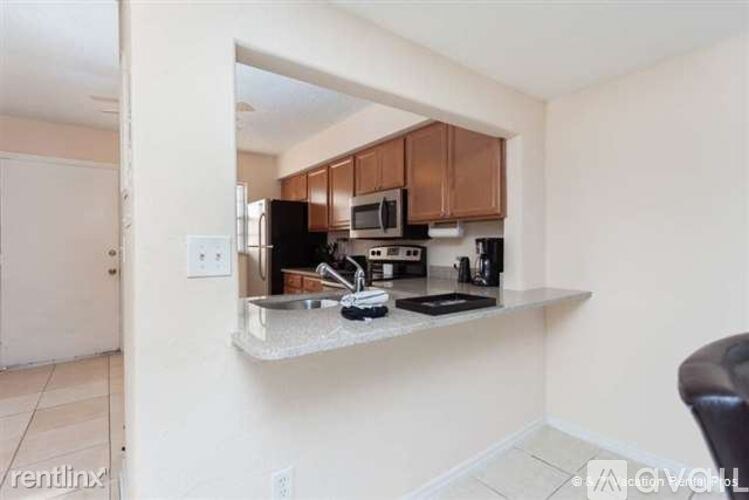 A kitchen with brown cabinets and a black countertop.