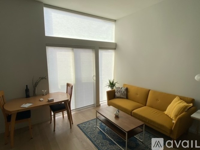 A living room with a yellow couch and a wooden table.