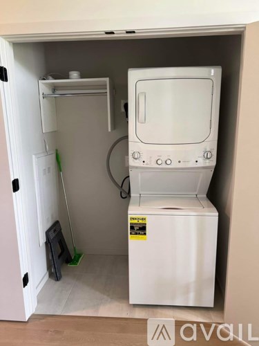 A white washing machine is in a cabinet.