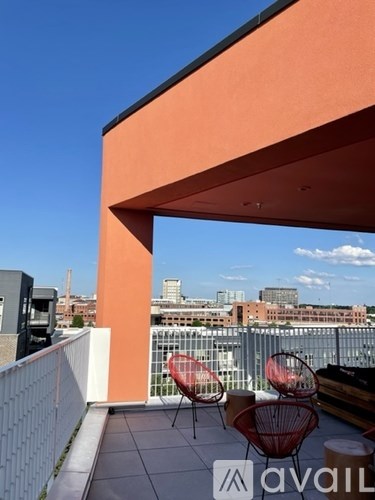 A balcony with chairs and a view of the city.