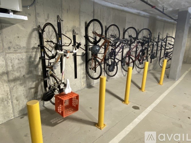 A bicycle parking area with multiple bikes secured to yellow posts.