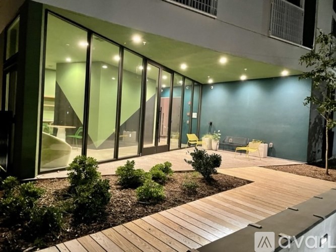 A modern building with glass walls and a wooden deck.