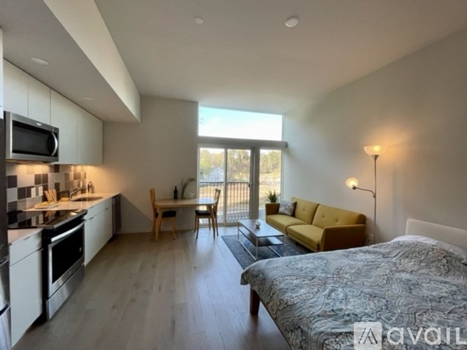 A well-lit, modern kitchen with a dining area and a bedroom.