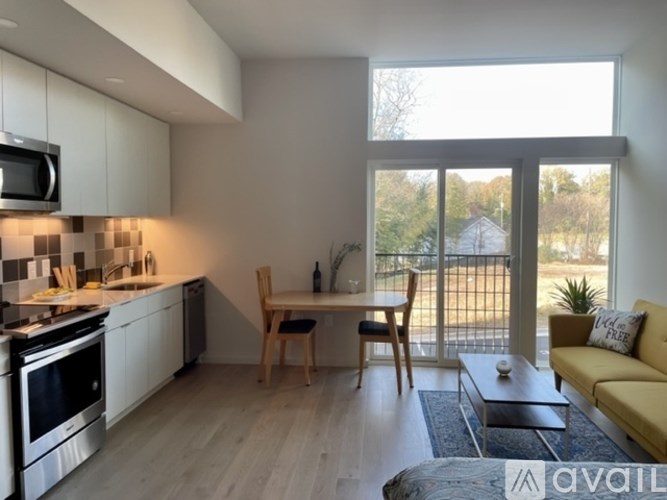 A modern kitchen with a dining area and a balcony.