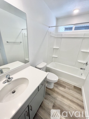 A bathroom with a white sink, toilet, and bathtub.