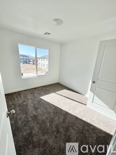 A room with a carpeted floor and a window showing an outdoor view.