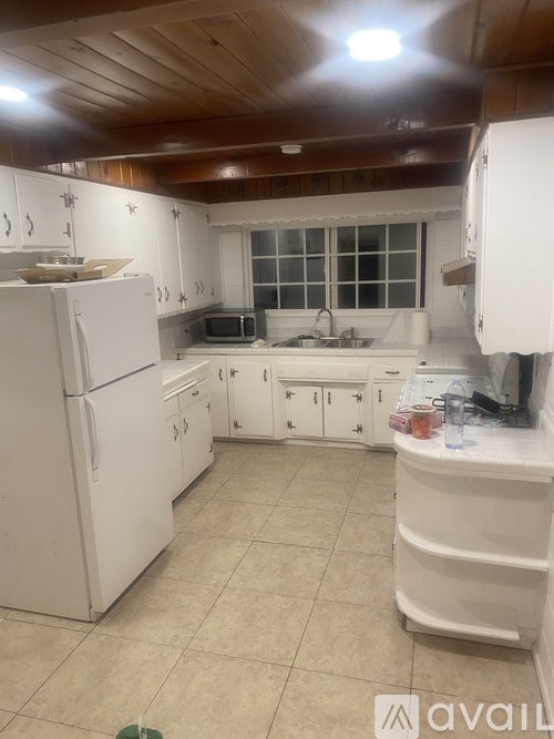 A kitchen with white appliances and cabinets.