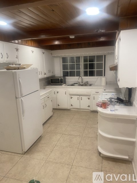 A kitchen with white appliances and cabinets.