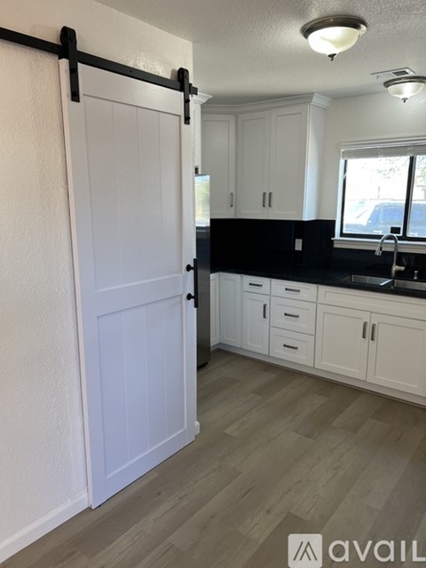 A kitchen with white cabinets and a black bar.