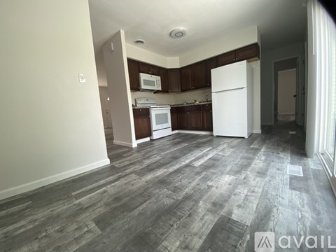 A kitchen area with a white refrigerator and wooden cabinets.