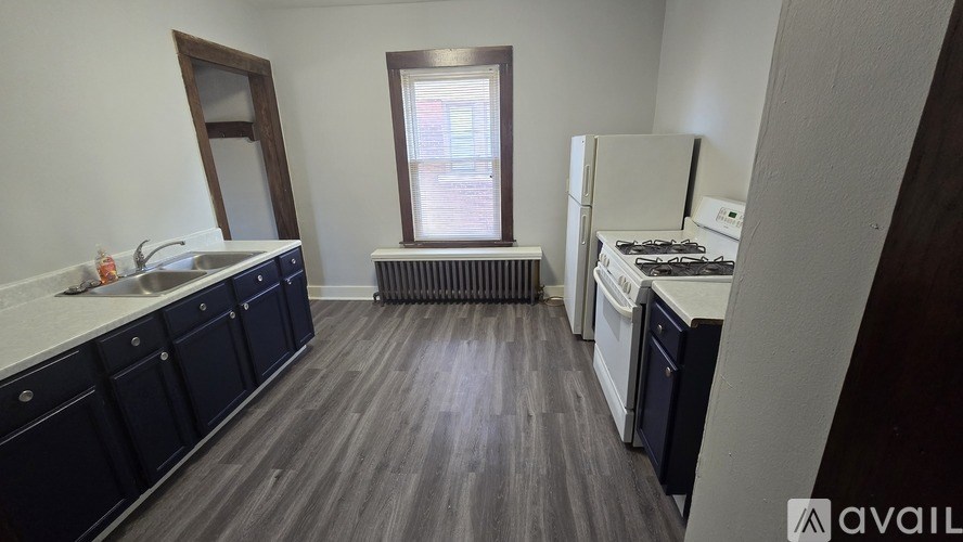 A kitchen with dark wood floors and white appliances.