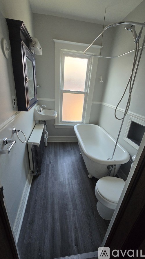 A bathroom with a tub, toilet and sink.