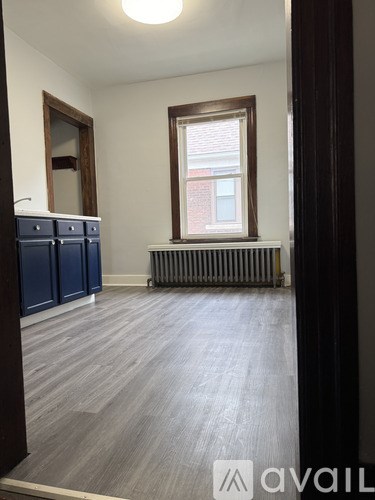 A room with a window and a radiator on the floor.