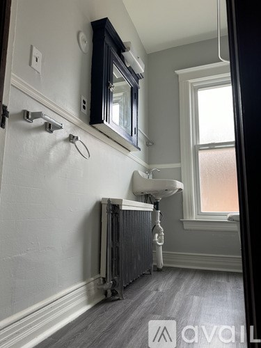 A bathroom with a white tub and grey floor.