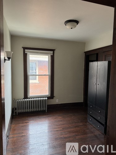 A room with a window and a radiator on the floor.