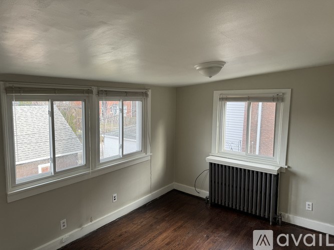 A room with a window and a radiator on the floor.
