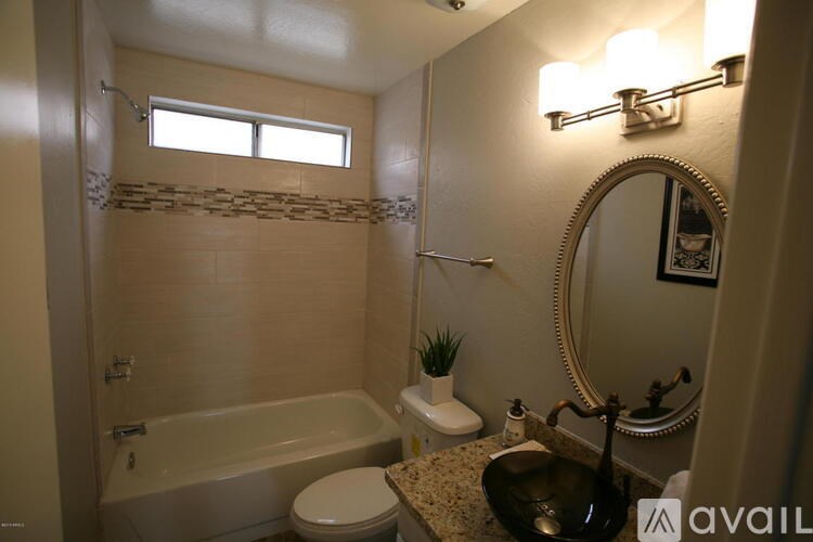 A bathroom with a tub, toilet, and sink.