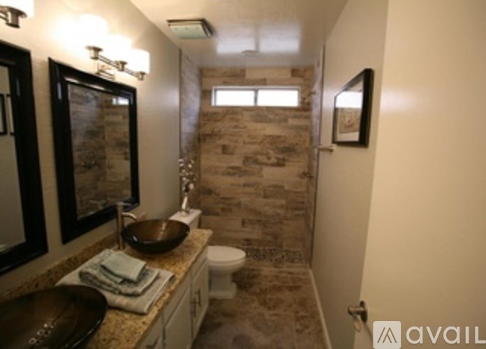 A bathroom with a toilet, sink, and mirror.