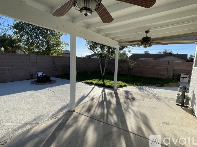 A patio with a ceiling fan and a concrete floor.