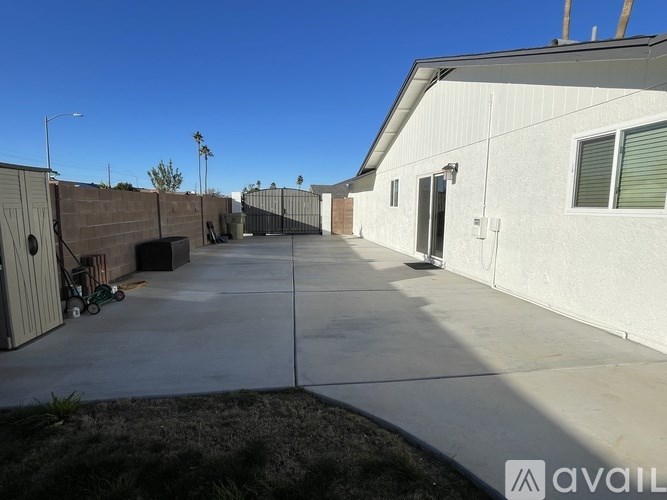 A parking lot in front of a building with a sign that says "AVAIL".