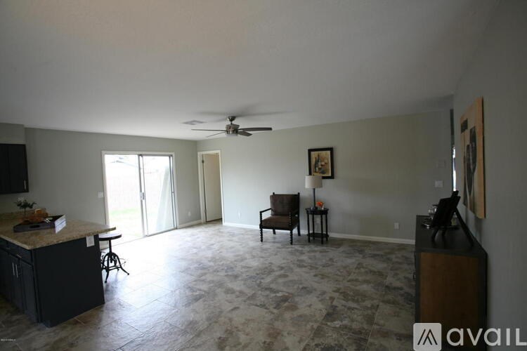 A living room with a kitchen area in the background.